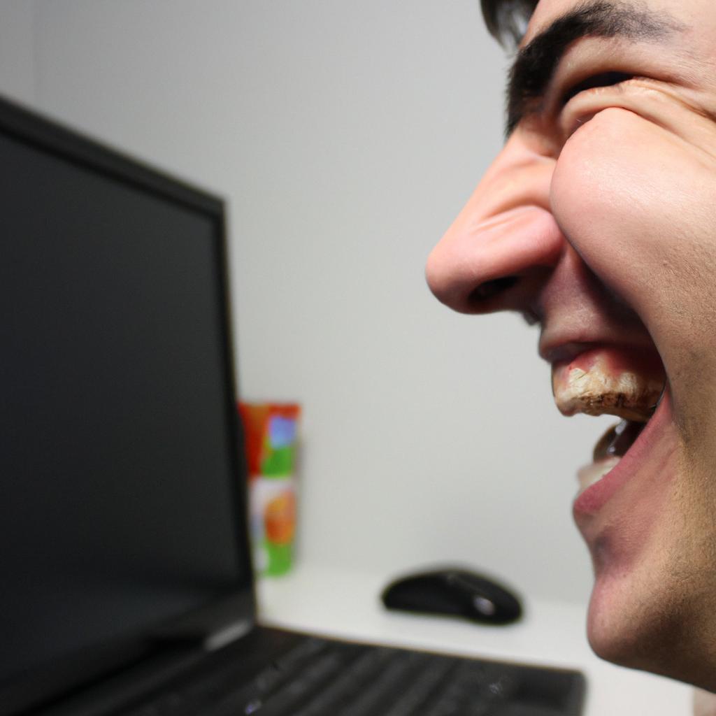 Person laughing at computer screen